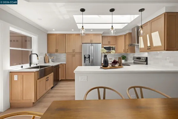 a kitchen with kitchen island granite countertop a sink a counter space appliances and cabinets