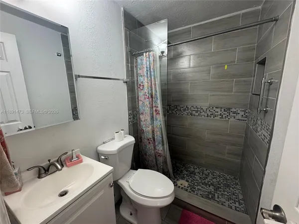a bathroom with a sink toilet and shower