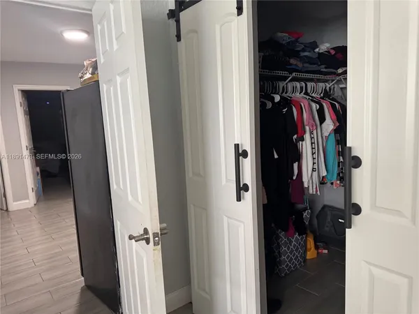 a view of walk in closet with clothes and shoes