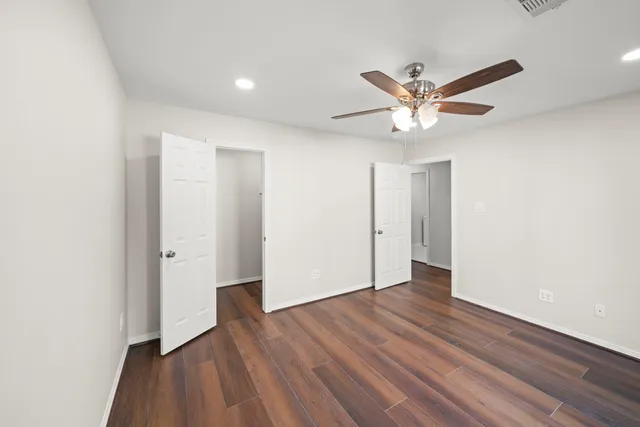 a view of empty room with wooden floor