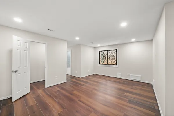 a view of an empty room with wooden floor