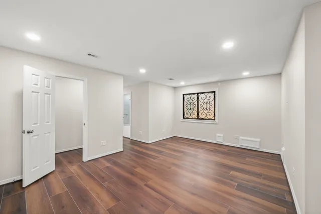 a view of an empty room with wooden floor