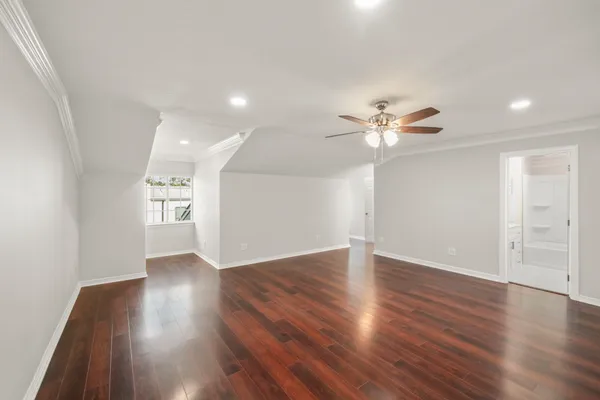 a view of an empty room with wooden floor