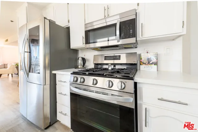 a kitchen with stainless steel appliances granite countertop a refrigerator stove and microwave