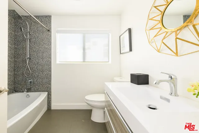 a bathroom with a tub sink and mirror