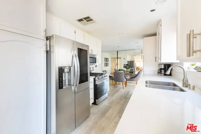 a kitchen with stainless steel appliances a refrigerator and a sink