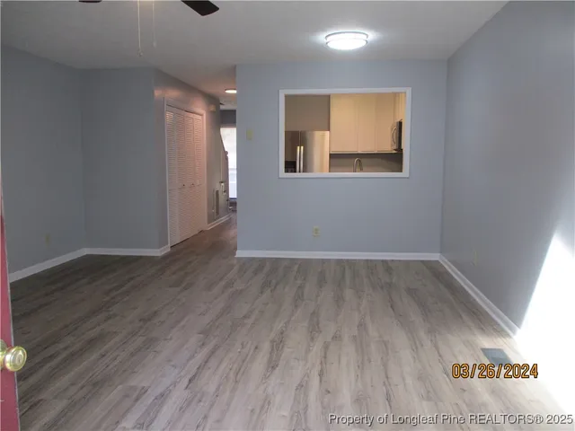 an empty room with wooden floor and windows