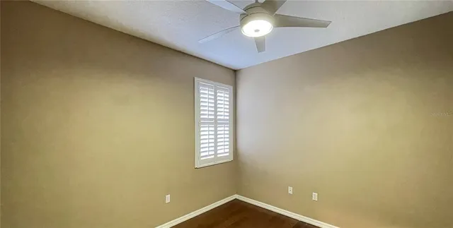 an empty room with wooden floor and mirror