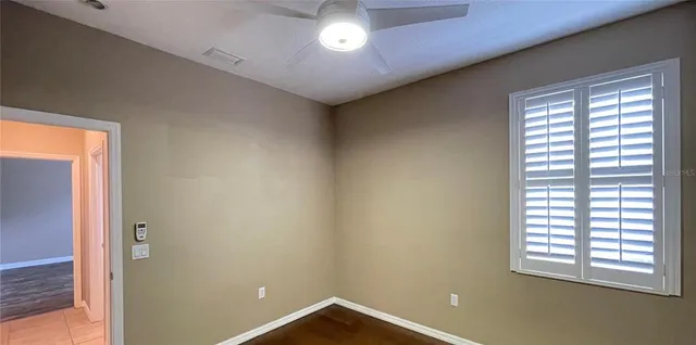 a view of an empty room with wooden floor