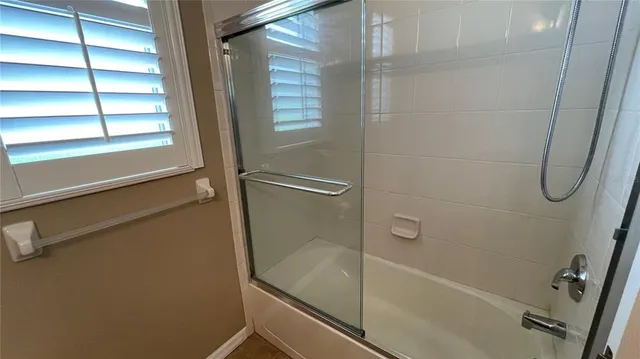 an empty room with wooden floor and a window