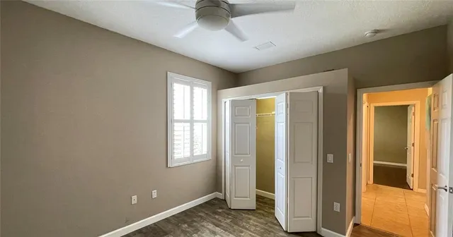 an empty room with a window and a fan
