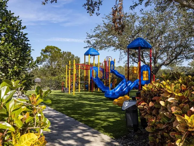 a view of swimming pool with outdoor seating and trees in the background