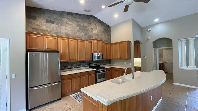 a kitchen with granite countertop a sink stainless steel appliances and cabinets