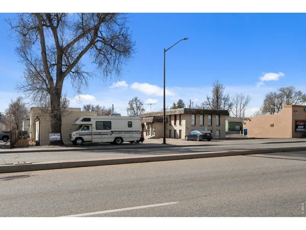 a view of a house with cars parked in front of it
