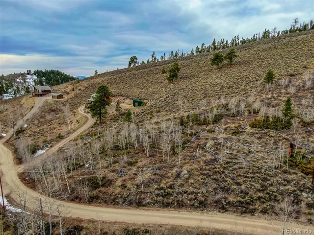 a view of a dry yard with wooden fence