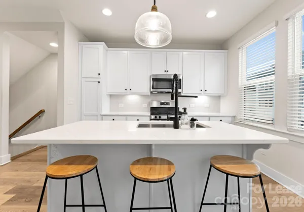 a kitchen with stainless steel appliances a sink and a chairs