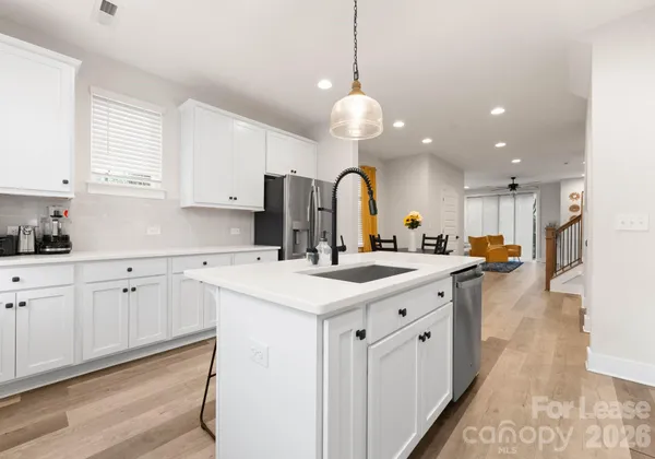 a large kitchen with kitchen island a sink appliances and cabinets