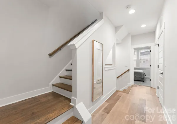 a view of a kitchen with white cabinets and wooden floor