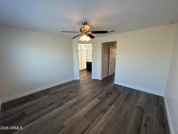 a view of a livingroom with wooden floor and fan