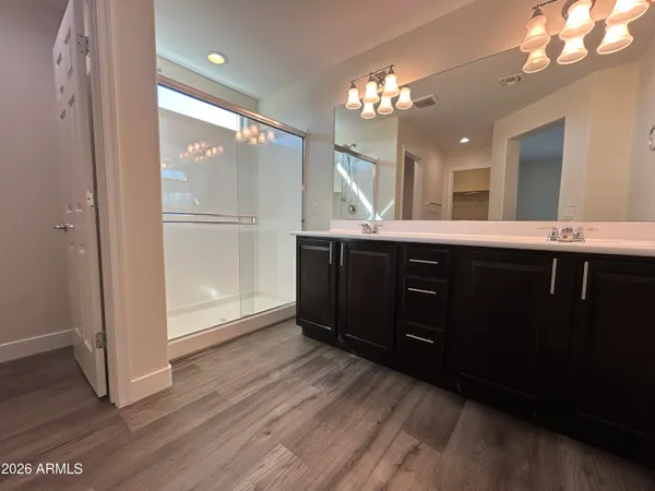 a spacious bathroom with a double vanity sink and mirror with shower
