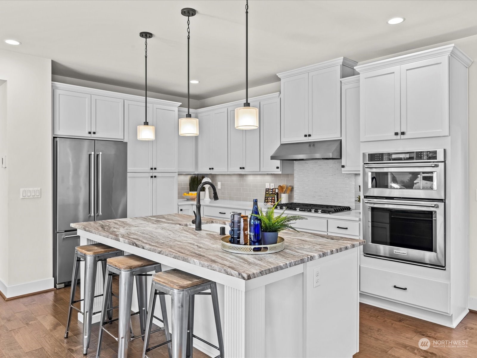 4431 187th Street Southeast Bothell, WA 98012 - Photo 11 of 39 a kitchen with stainless steel appliances granite countertop a stove a refrigerator a sink a oven and white cabinets with wooden floor