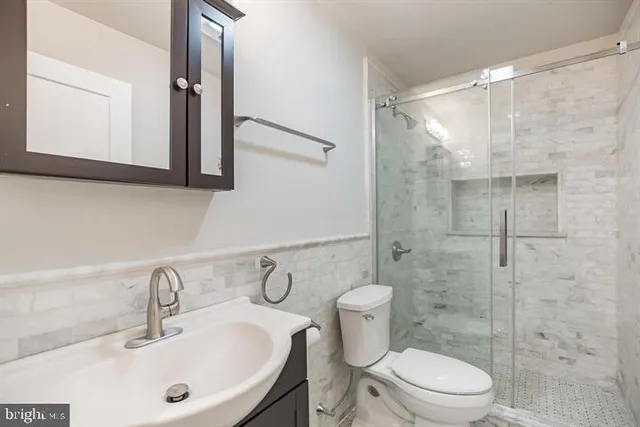 a bathroom with a toilet sink shower and mirror