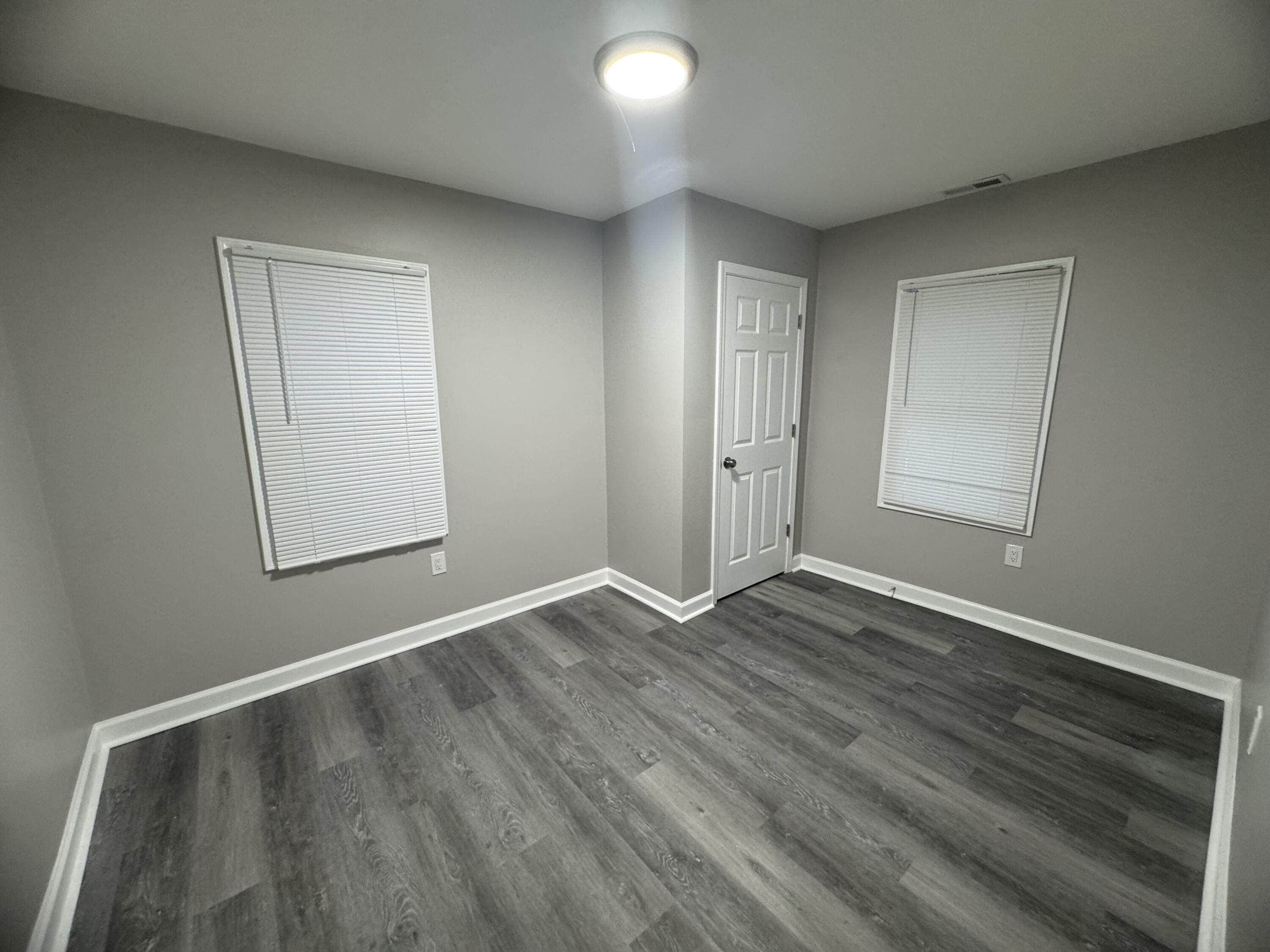 3428 Delaware Street Gary, IN 46409 - Photo 9 of 13 an empty room with wooden floor and windows