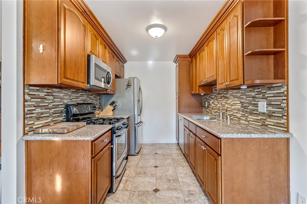 601 East Orange Grove Avenue, Unit 106 Burbank, CA 91501 - Photo 14 of 27 a kitchen with stainless steel appliances granite countertop a stove and a refrigerator