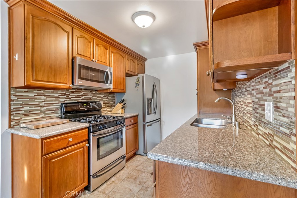 601 East Orange Grove Avenue, Unit 106 Burbank, CA 91501 - Photo 15 of 27 a kitchen with stainless steel appliances granite countertop a sink stove and refrigerator