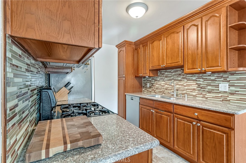 601 East Orange Grove Avenue, Unit 106 Burbank, CA 91501 - Photo 16 of 27 a kitchen with wooden cabinets and a sink