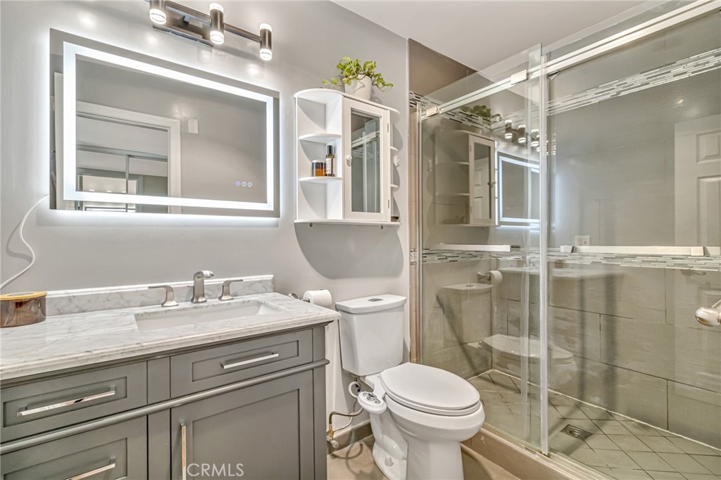 601 East Orange Grove Avenue, Unit 106 Burbank, CA 91501 - Photo 23 of 27 a bathroom with a granite countertop sink toilet and shower