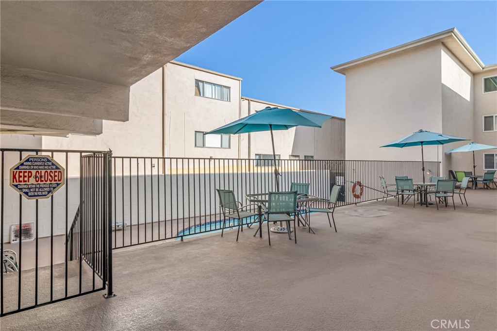 601 East Orange Grove Avenue, Unit 106 Burbank, CA 91501 - Photo 8 of 27 a view of a patio with a table and chairs under an umbrella