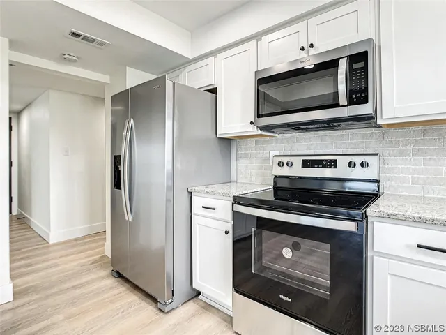 a kitchen with stainless steel appliances a stove a microwave and cabinets