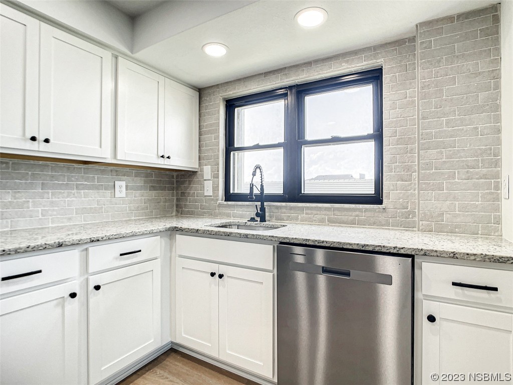 4435 South Atlantic Avenue, Unit 311 Ponce Inlet, FL 32127 - Photo 13 of 44 a kitchen with granite countertop a sink and a window