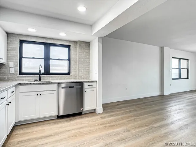 a view of a kitchen with granite countertop cabinets and wooden floor