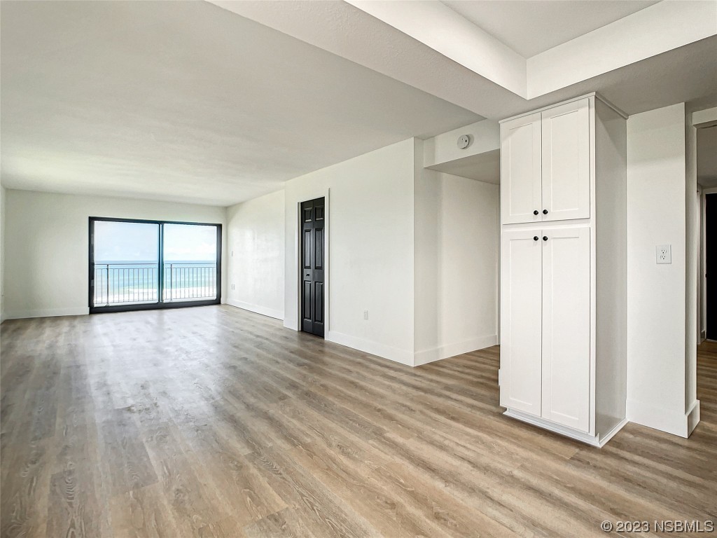 4435 South Atlantic Avenue, Unit 311 Ponce Inlet, FL 32127 - Photo 15 of 44 a view of an empty room with wooden floor and a window