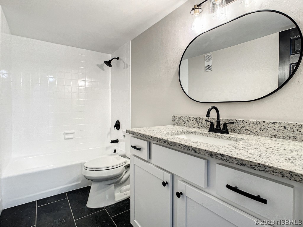 4435 South Atlantic Avenue, Unit 311 Ponce Inlet, FL 32127 - Photo 21 of 44 a bathroom with a granite countertop toilet sink and mirror