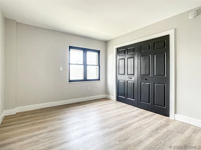 a view of an empty room with wooden floor