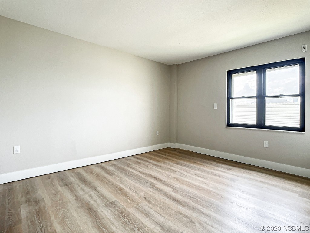4435 South Atlantic Avenue, Unit 311 Ponce Inlet, FL 32127 - Photo 24 of 44 wooden floor in an empty room with a window