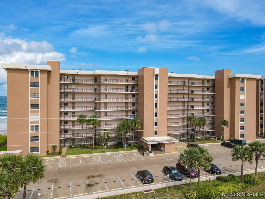 4435 South Atlantic Avenue, Unit 311 Ponce Inlet, FL 32127 - Photo 8 of 44 a front view of a building with glass windows and plants