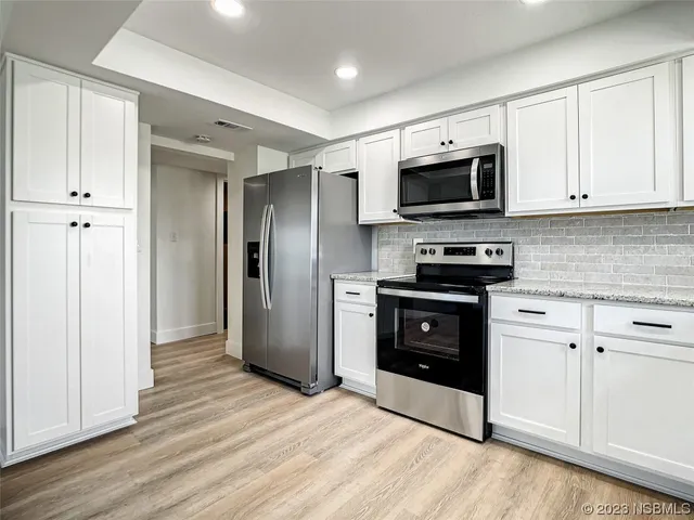a kitchen with stainless steel appliances granite countertop a stove and a refrigerator