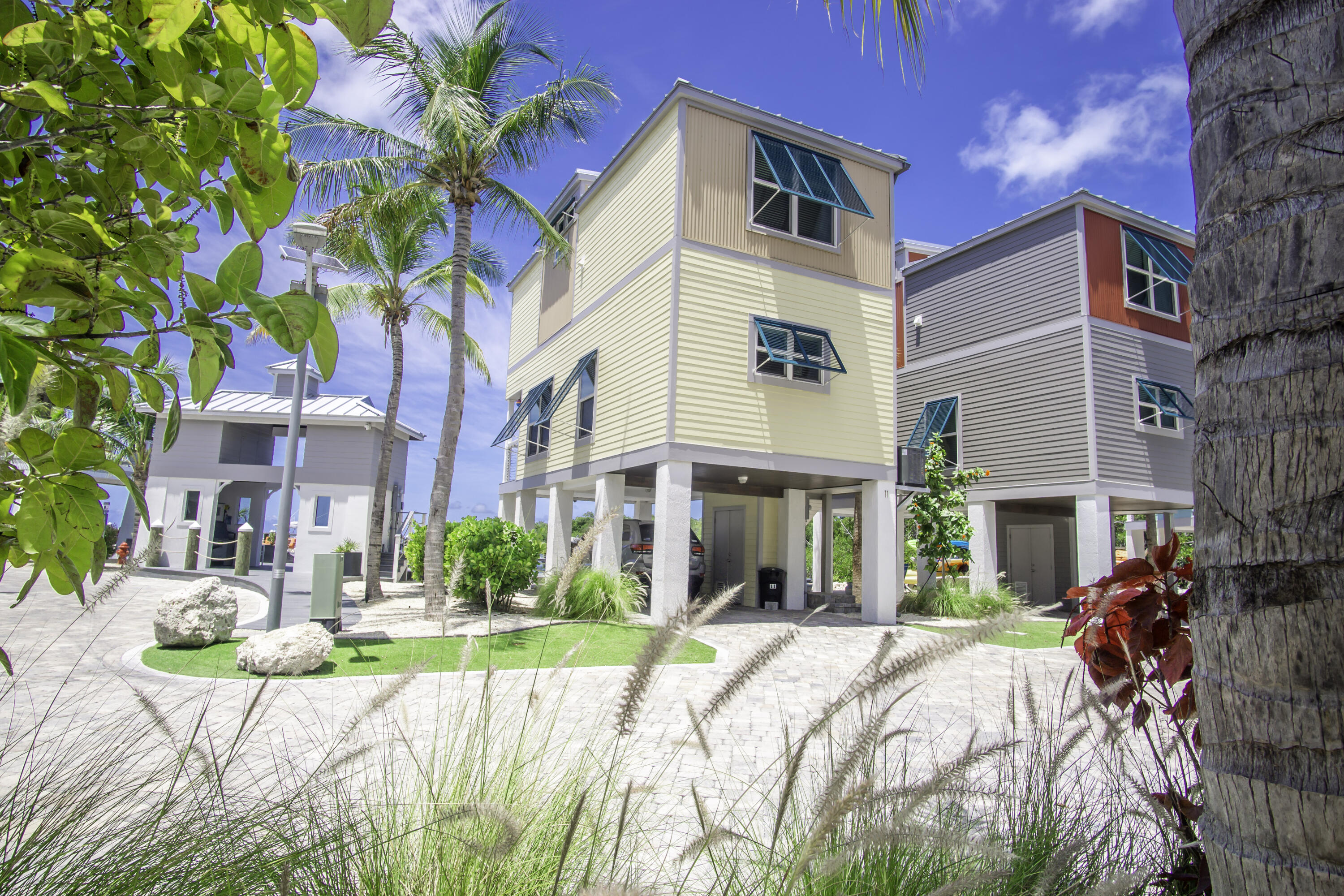101 11th Street, Unit 11 Marathon, FL 33050 - Photo 47 of 67 a view of a white house with a yard and potted plants