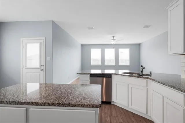 a kitchen with granite countertop a sink and a stove