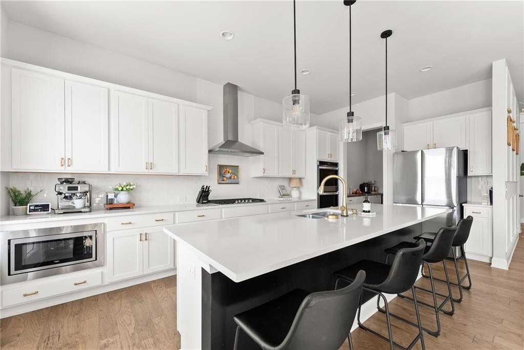 3675 Andover Street Cumming, GA 30028 - Photo 15 of 52 a kitchen with stainless steel appliances a sink a stove a refrigerator and white cabinets