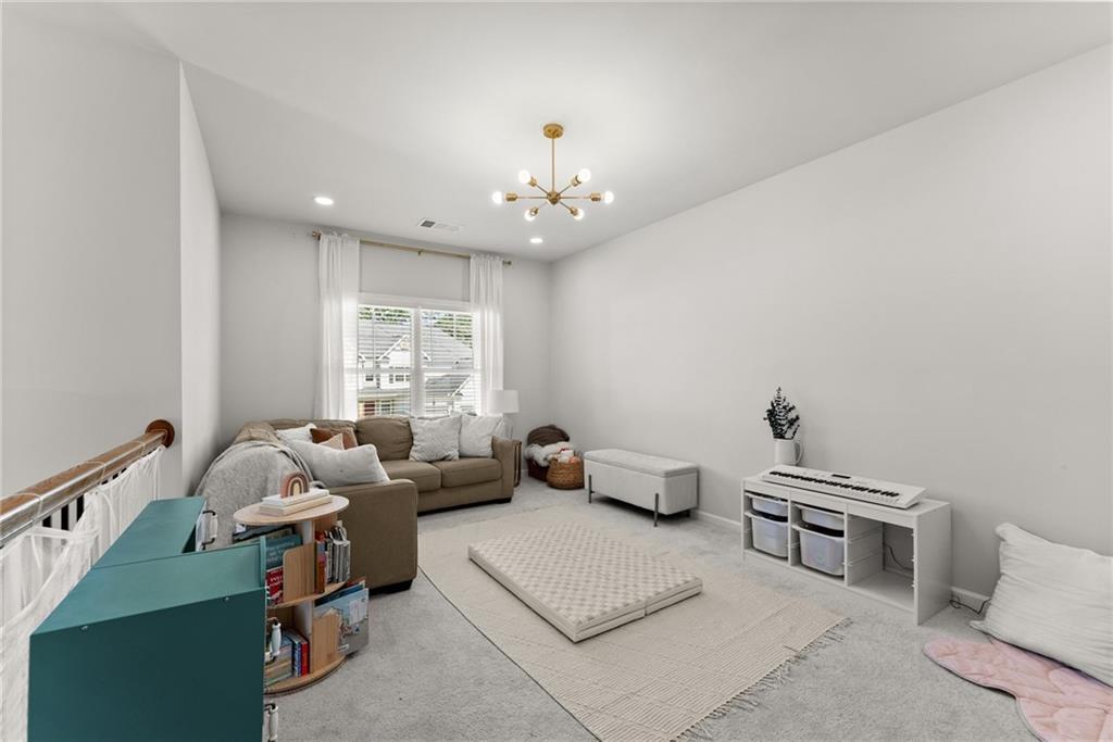 3675 Andover Street Cumming, GA 30028 - Photo 41 of 52 a living room with furniture and a chandelier