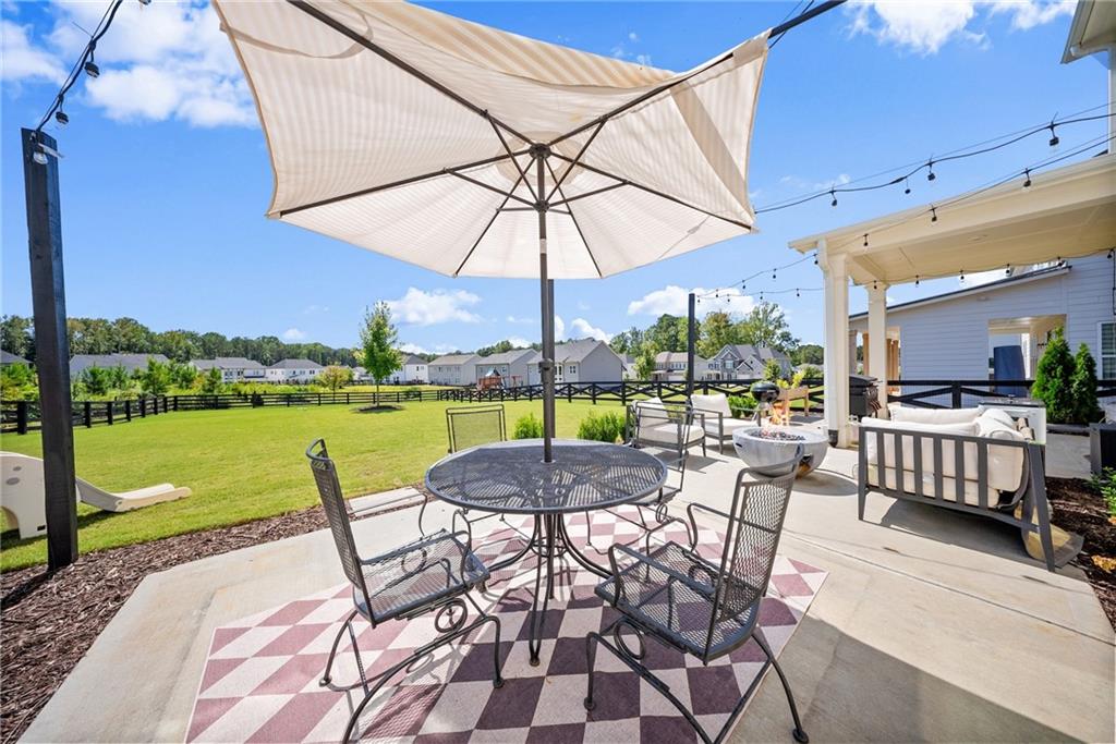 3675 Andover Street Cumming, GA 30028 - Photo 45 of 52 a view of a patio with a table chairs and a backyard