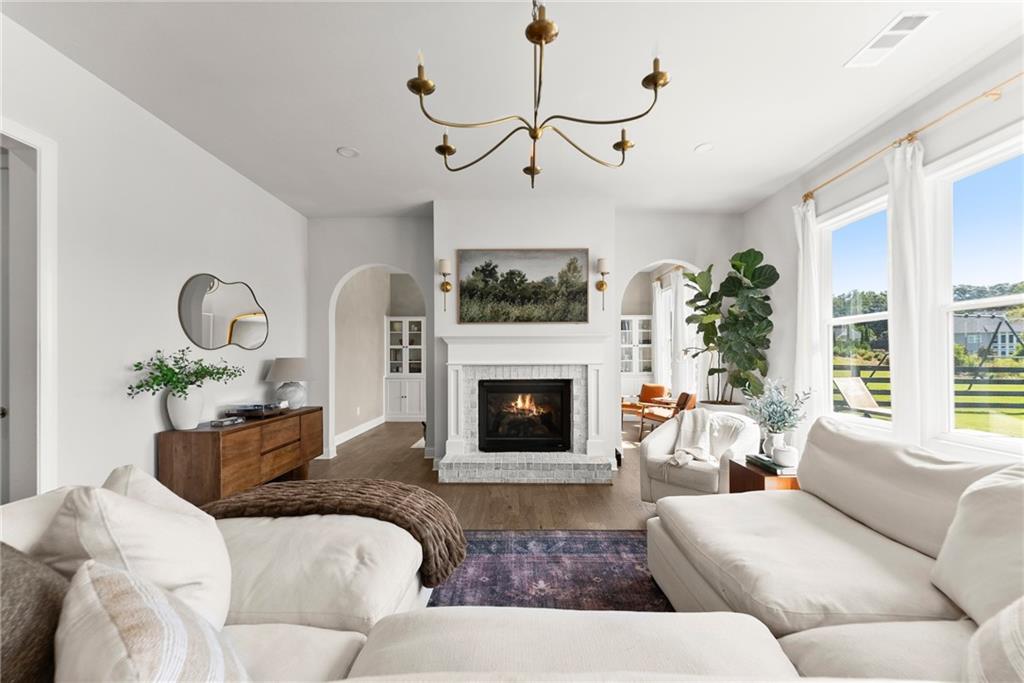 3675 Andover Street Cumming, GA 30028 - Photo 6 of 52 a living room with furniture a fireplace and windows