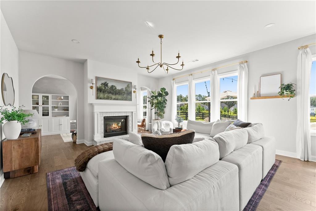 3675 Andover Street Cumming, GA 30028 - Photo 7 of 52 a living room with furniture a chandelier and a fireplace