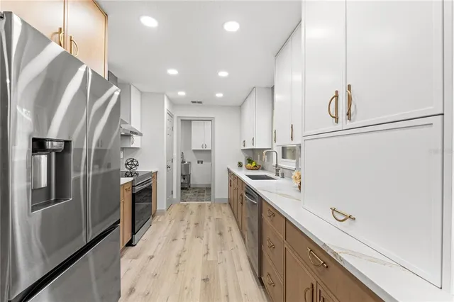 a kitchen with stainless steel appliances a refrigerator sink and stove