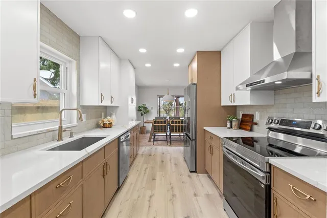 a kitchen with stainless steel appliances a sink stove and cabinets